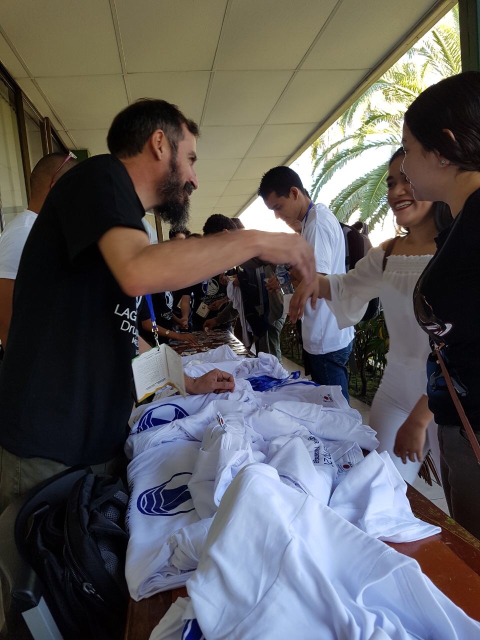 Camp volunteers passing out t-shirts to attendees.