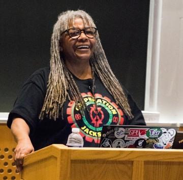 Michele Metts at podium smiling.