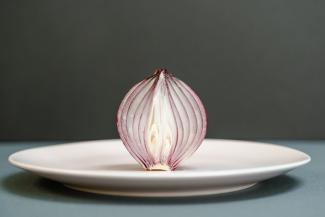 A red onion sitting on a plate.