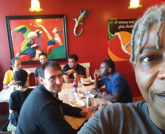 A selfie by Micky Metts in a colorful, casual Mexican restaurant with Martin Owens, Chris Thompson, Mauricio Dinarte and others over her shoulder.